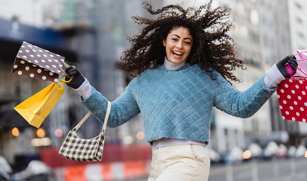 happy woman jumping with shopping bags