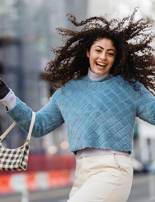 happy woman jumping with shopping bags