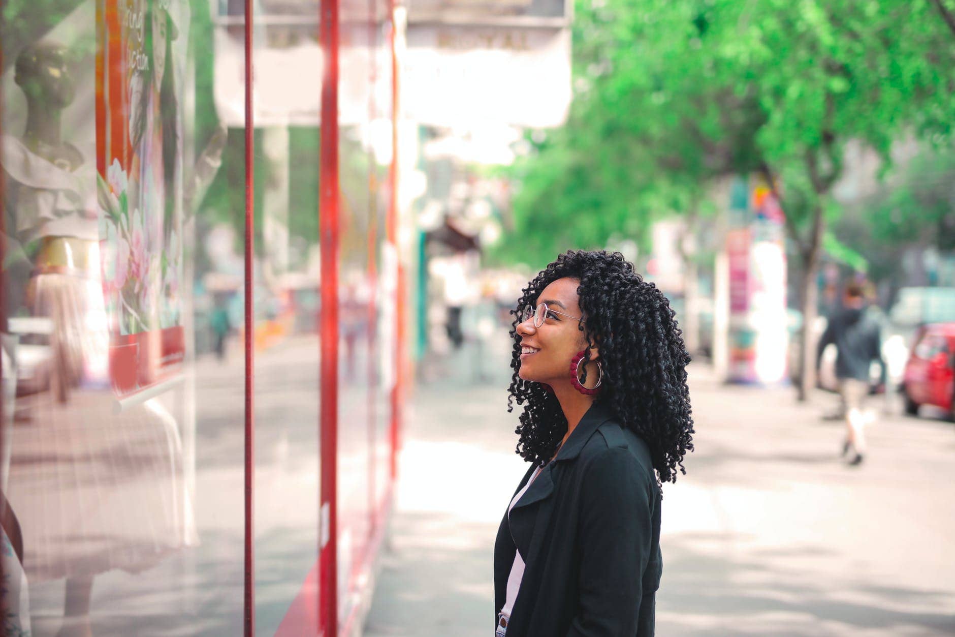woman in black coat standing on sidewalk